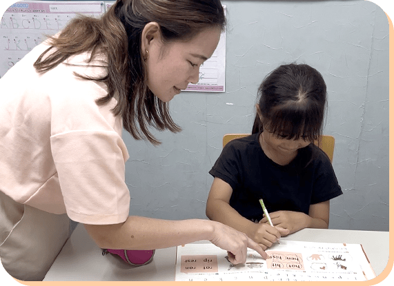 教材を使って子どもに指導する先生