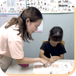 教材を使って子どもに指導する先生