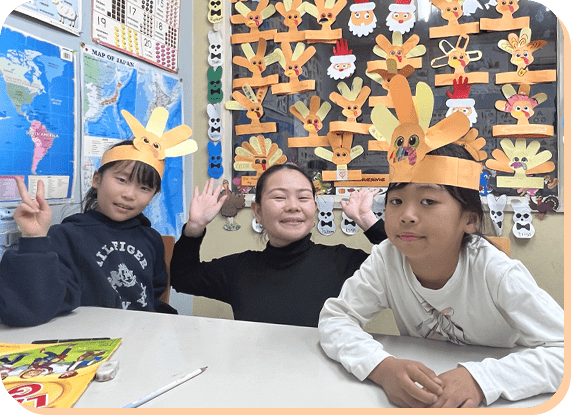 クラフト帽子をかぶる子どもたちと先生