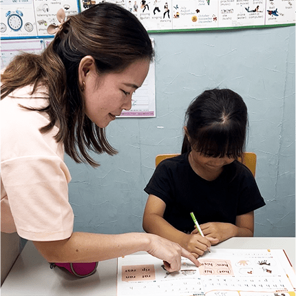 教材を使って学習する子どもと先生