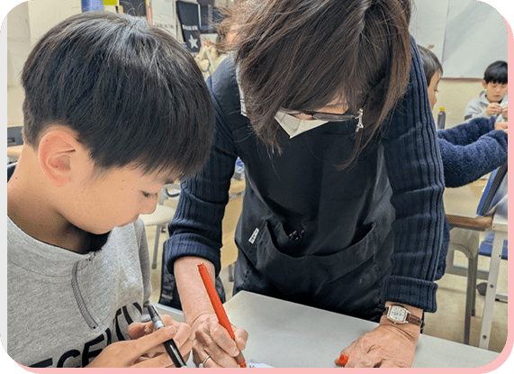 先生と一緒に書道を学ぶ男の子