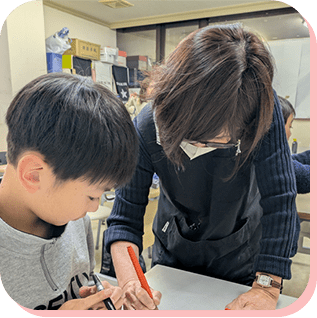 先生と一緒に書道を学ぶ男の子