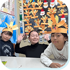 クラフト帽子をかぶる子どもたちと先生